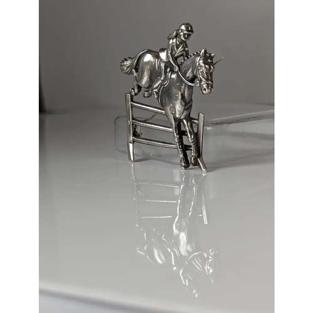 Silver steed triple bar jump jumping brooch silver equestrian stock tie pin showing rider and horse mid-jump