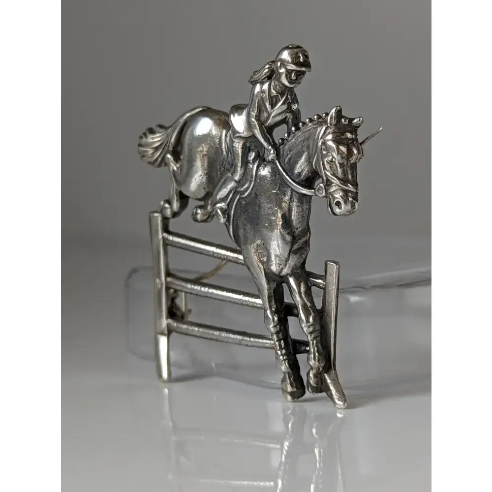 Silver steed triple bar jump stock tie pin featuring a silver metal jumping brooch of rider on horseback