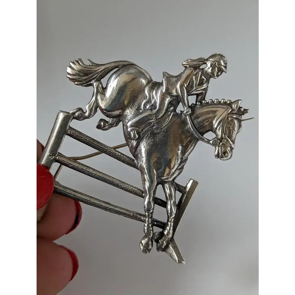 Silver steed triple jumping brooch showing a rider and horse mid-jump silver stock tie pin design