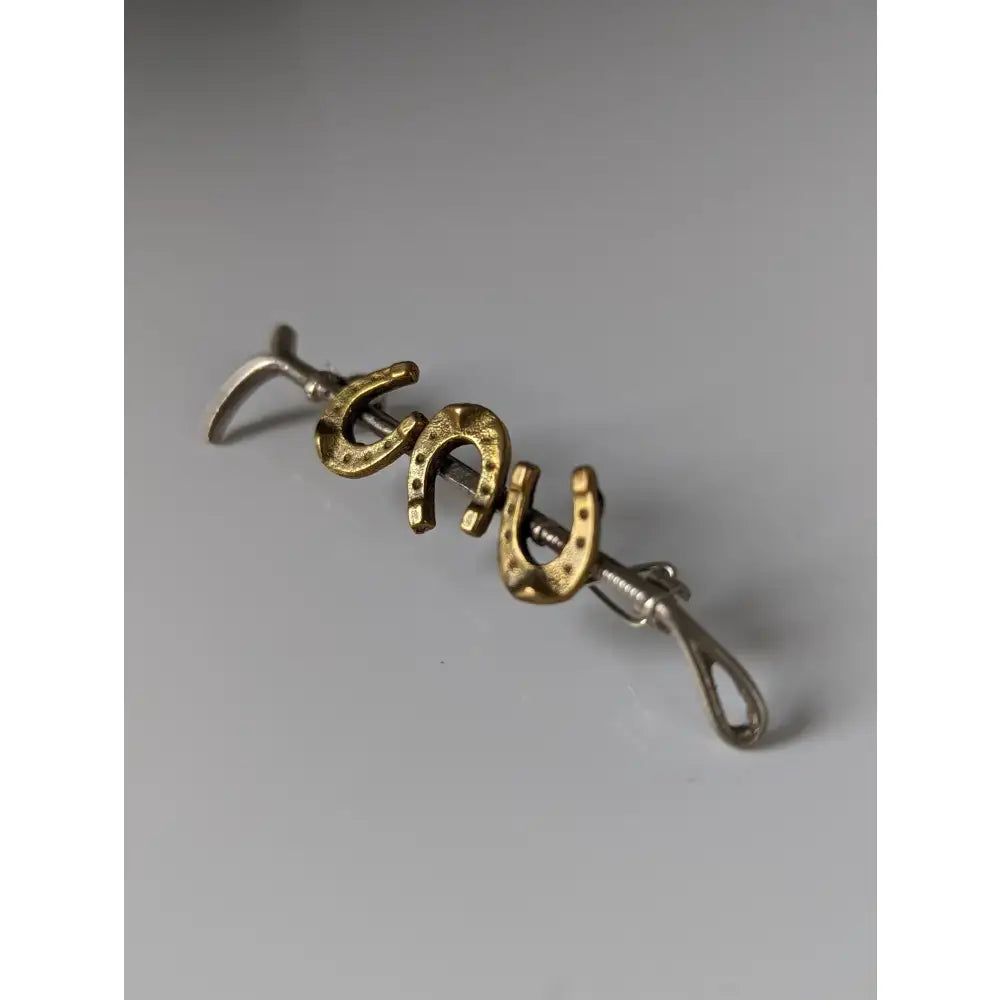 Gold accent horseshoe letter charms spelling lucky on a silver steed triple cane brooch chain with clasp