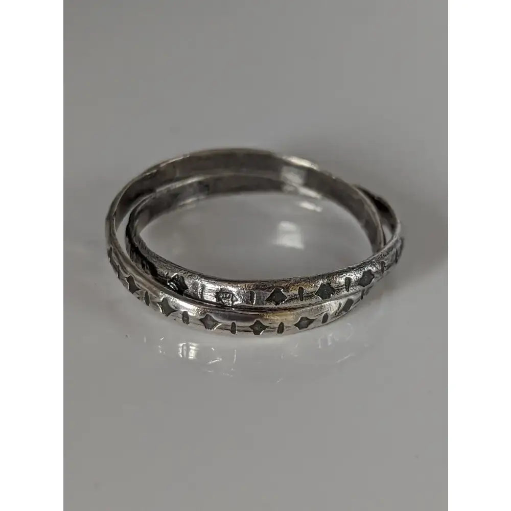 Silver steed handmade silver band ring with two interlinking bands and intricate geometric etching on the outer edge