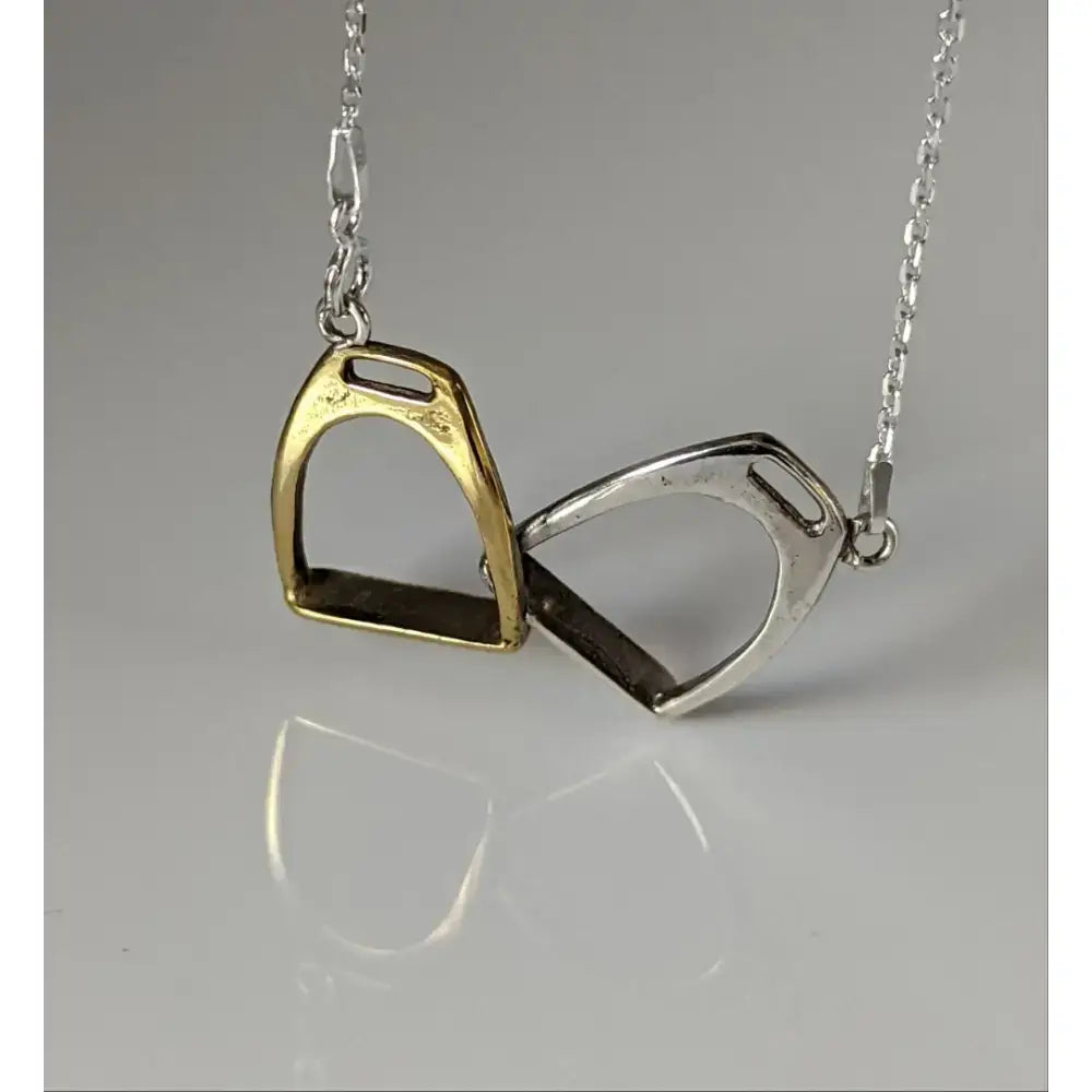 A delicate silver steed two stirrups necklace with interlocking gold and silver-toned stirrups necklace pendants