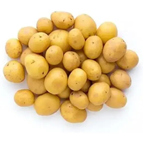 A pile of small salad potatoes with rough yellow skin and minor dark spots perfect for salads