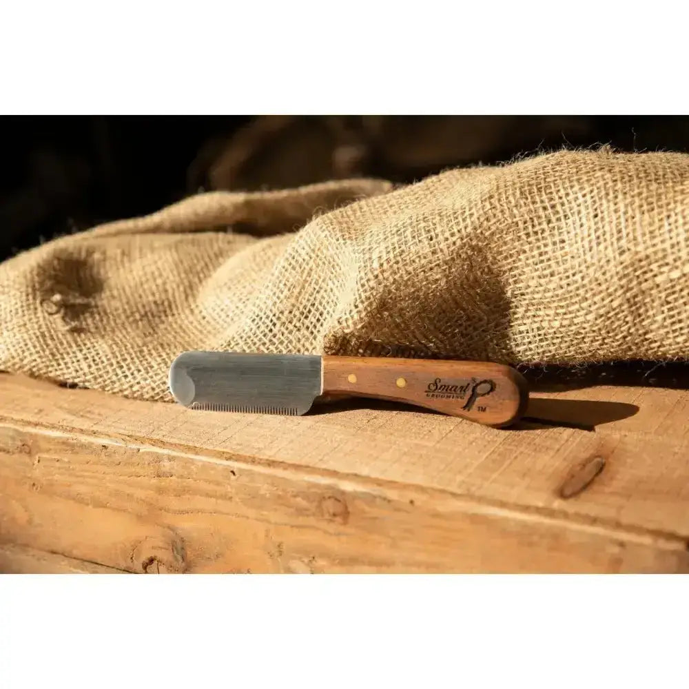 A sleek silver smart grooming pro levelling thinning knife with a warm brown wooden handle and doran logo