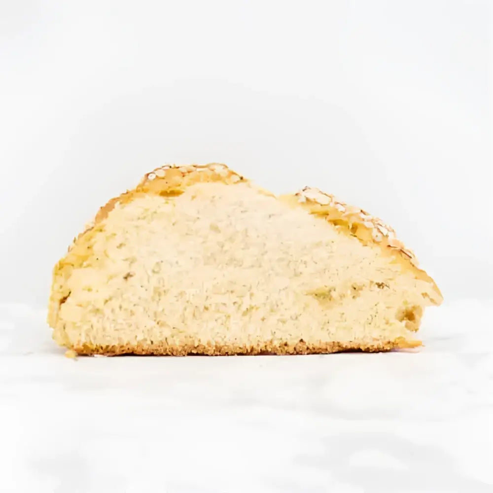 A golden brown crusty round white bread loaf with airy interior and seeds, perfect soda bread option