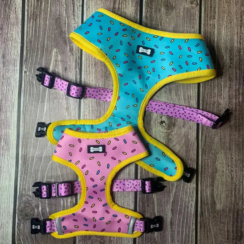 Two reversible dog harnesses in sprinkle print yellow trim turquoise and soft pink with black buckles from sprinkles for days