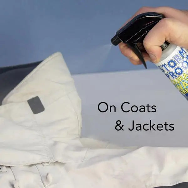 Black stormproof water repellent spray 500ml being used on a white coat without nauseating chemical smell