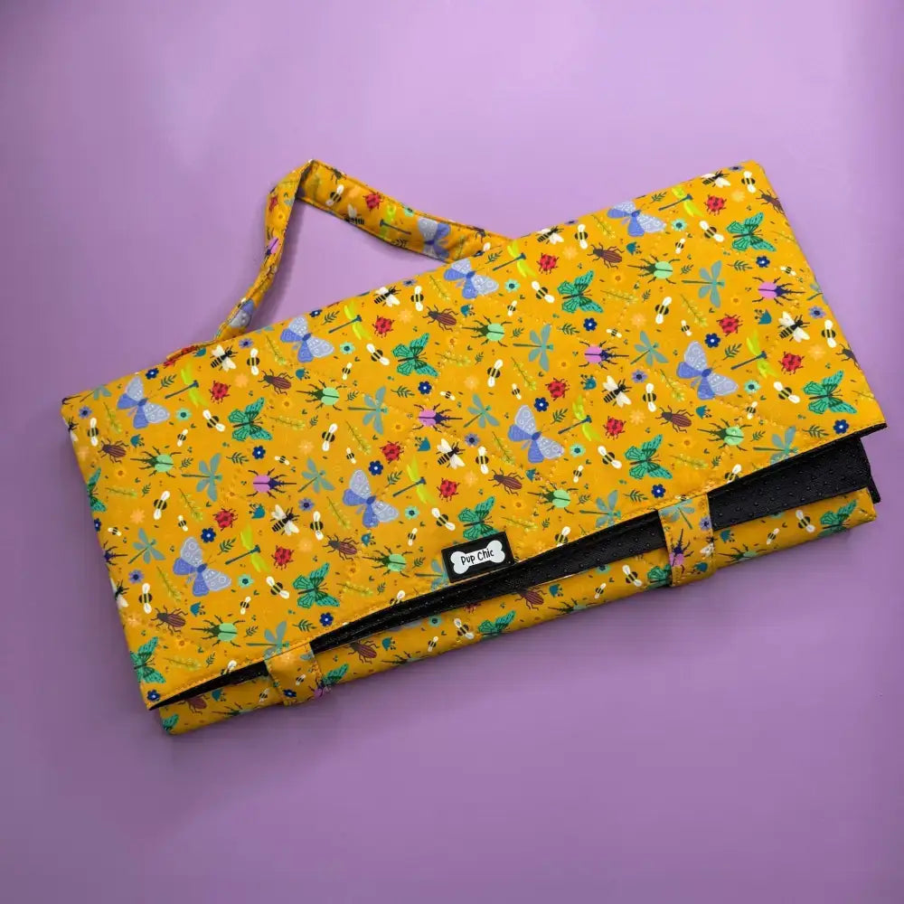 A vibrant yellow summer buzzin dog settle mat with bees butterflies flowers lightweight waterproof and travel-friendly