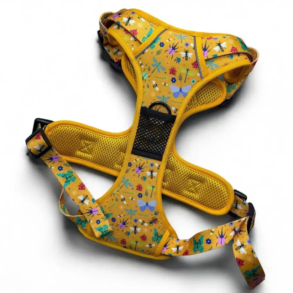 A vibrant yellow insect print tactical dog harness with bees and butterflies pattern for buzzin tactical dog walks