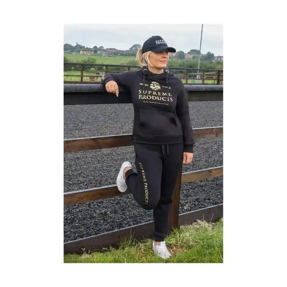 Black supreme products active rider hoodie with gold lettering and logo paired with matching joggers