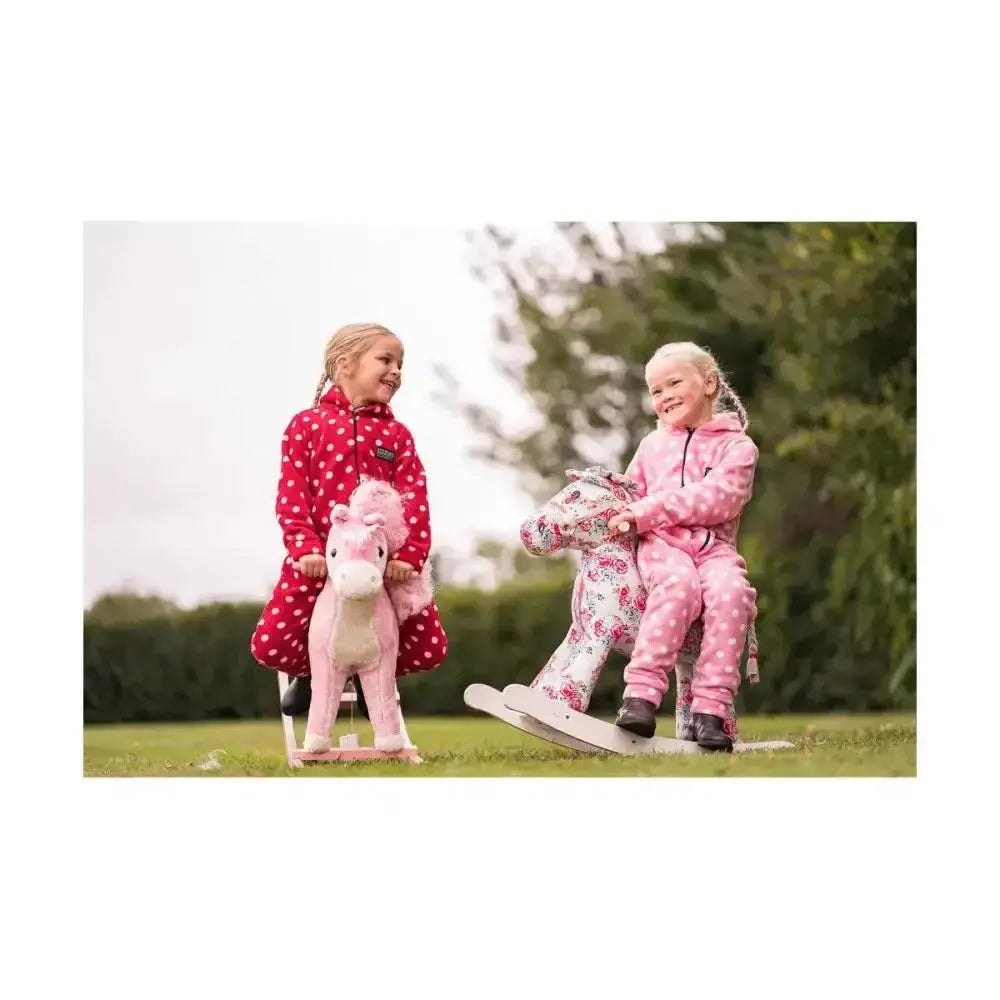 Pink plush rocking horse with floral pattern and white wooden base shown with supreme products childs dotty fleece onesie