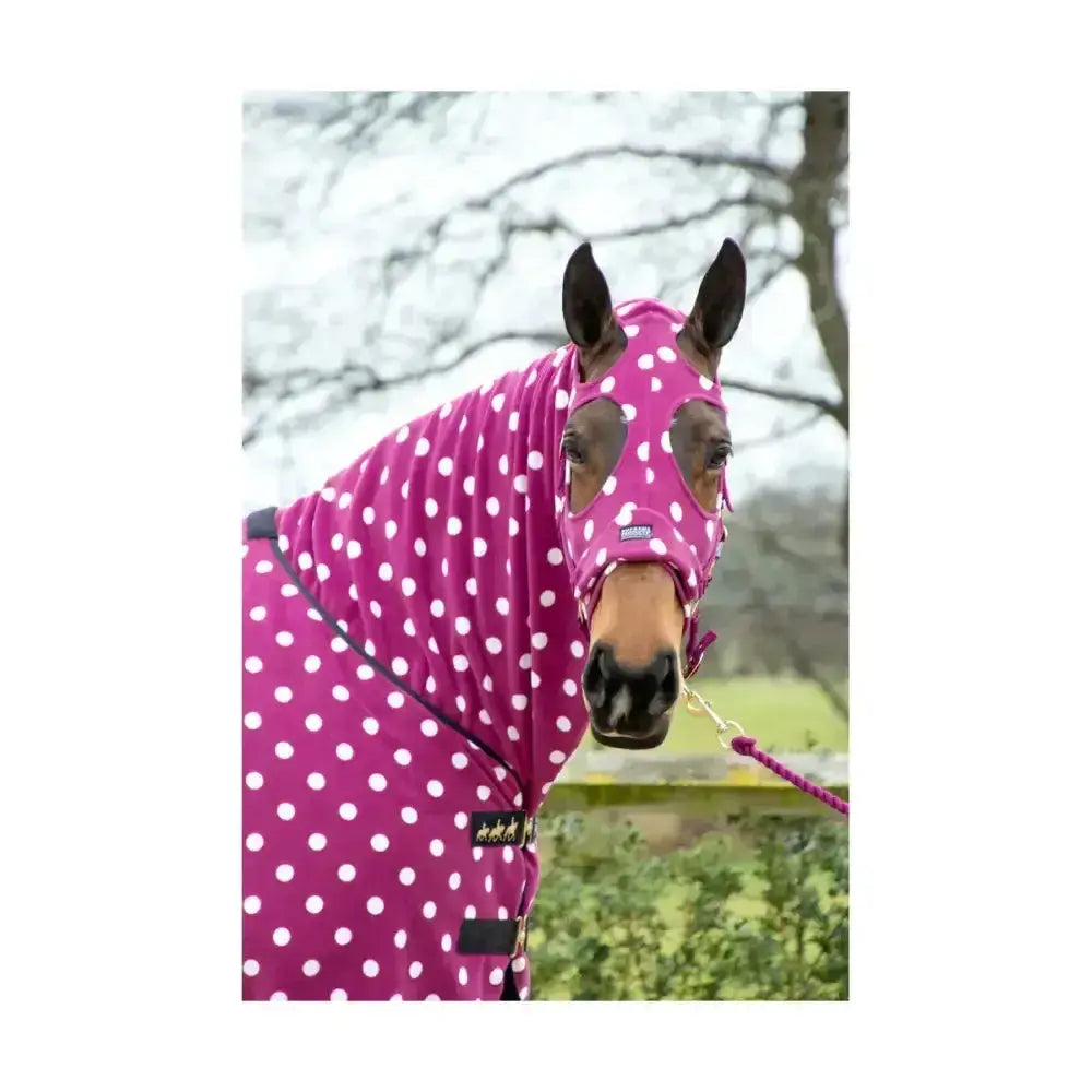 A vibrant pink supreme products dotty fleece hood with white polka dots, snug hood, and black trim for warmth