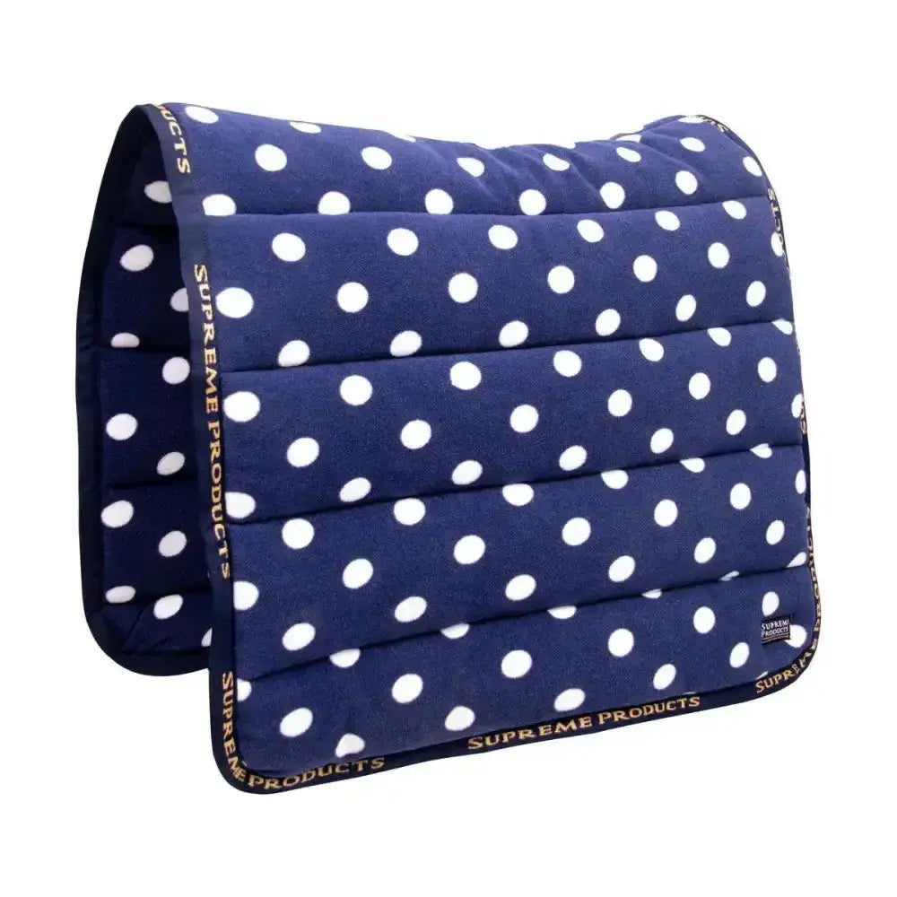 Navy blue quilted fleece saddle pad with white polka dots and supreme products dotty branding on the edges