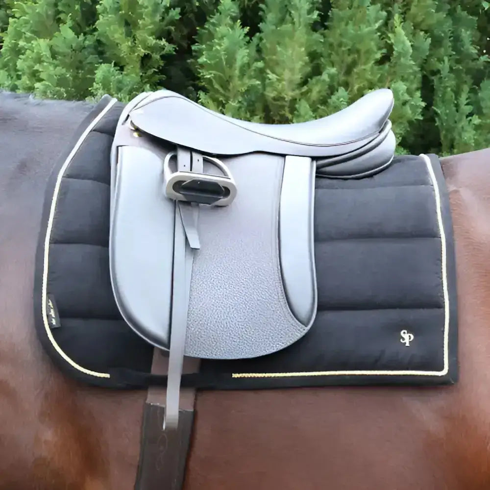 Silver leather saddle with textured front and stitched edges on a black quilted lightweight saddle pad supreme products royal occasion suede saddle