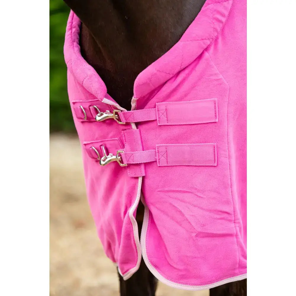 Bright pink mulberry fleece horse rug with quilted design silver buckles white trim and cross surcingles luxury fleece rug