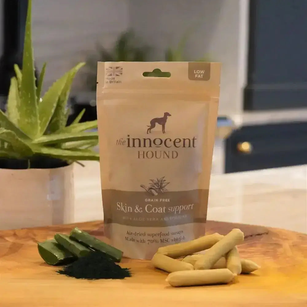 A beige pouch of innocent hound skin and coat support sausage treats with aloe vera and a dog silhouette design