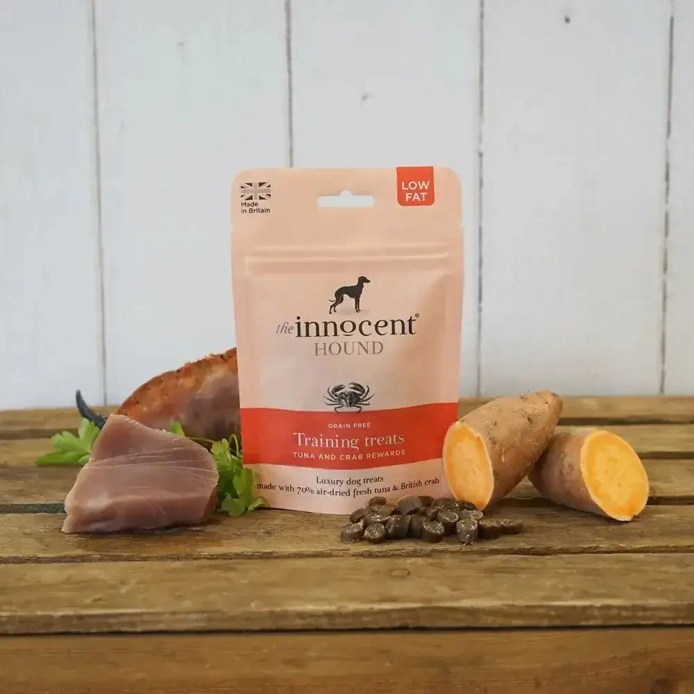 A pink and orange innocent hound pouch of grain-free training treats with succulent sliced tuna and crab rewards
