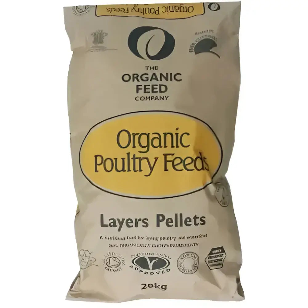 A beige bag of the organic feed company organic layers pellets farmyard layers feed with a yellow oval logo and black text