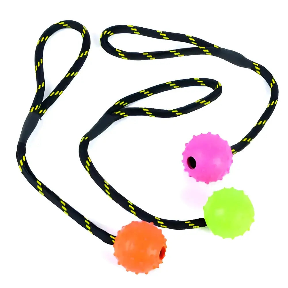 A tough toys studded rope ball floater dog toy with three colorful spiky spheres and a black rope with yellow stitching