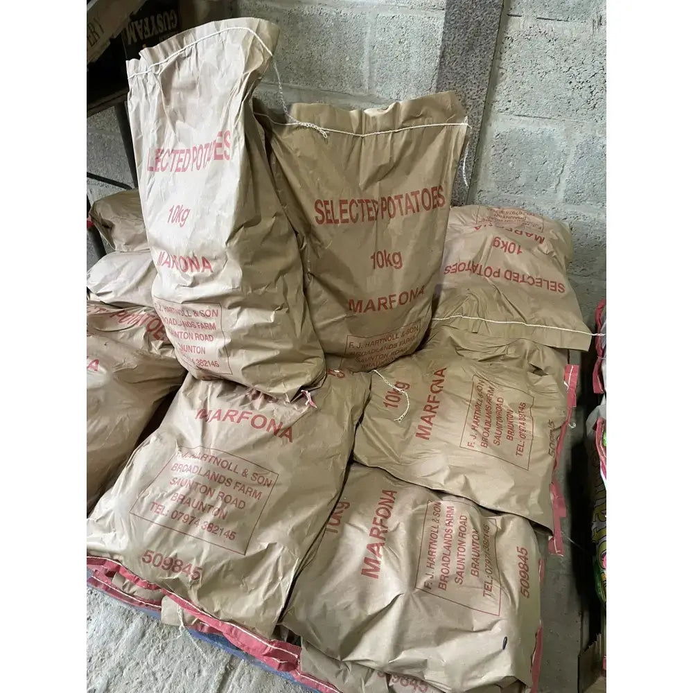 Brown paper sacks labeled selected potatoes and marfona hold 10kg of washed potatoes for easy storage and use