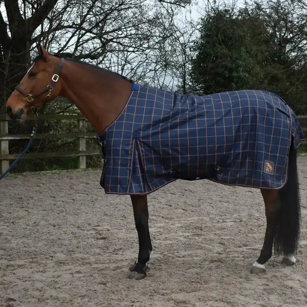 Blue plaid whitaker jacob lightweight turnout rug with red white grid lines and logo patch on the side
