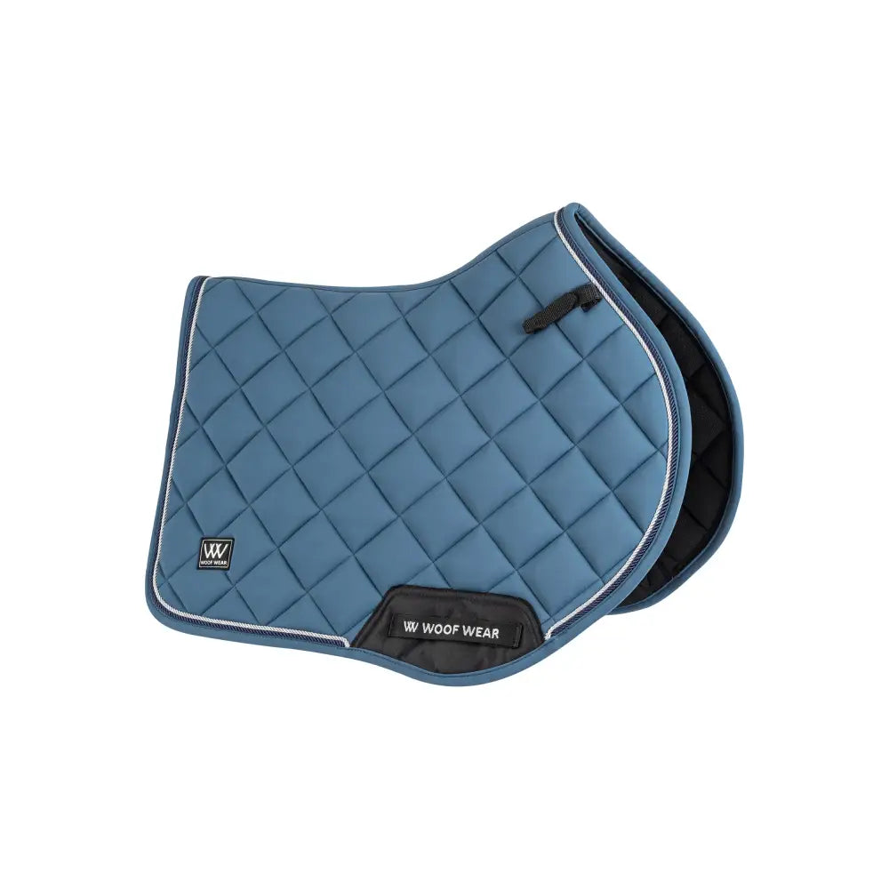 Blue quilted close contact saddle pad with black trim and woof wear label from vision aura collection