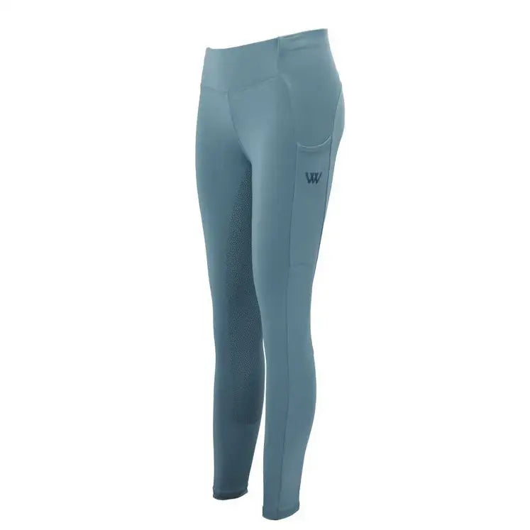 A pair of teal woof wear young rider pro tights with textured outer thigh panel and seat silicone grip logo patch near hip