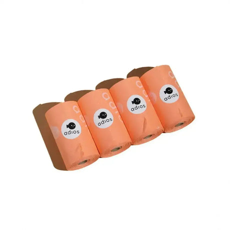 Four rolls of peach-colored adios non handle poo bags made of plastic for easy pet waste cleanup