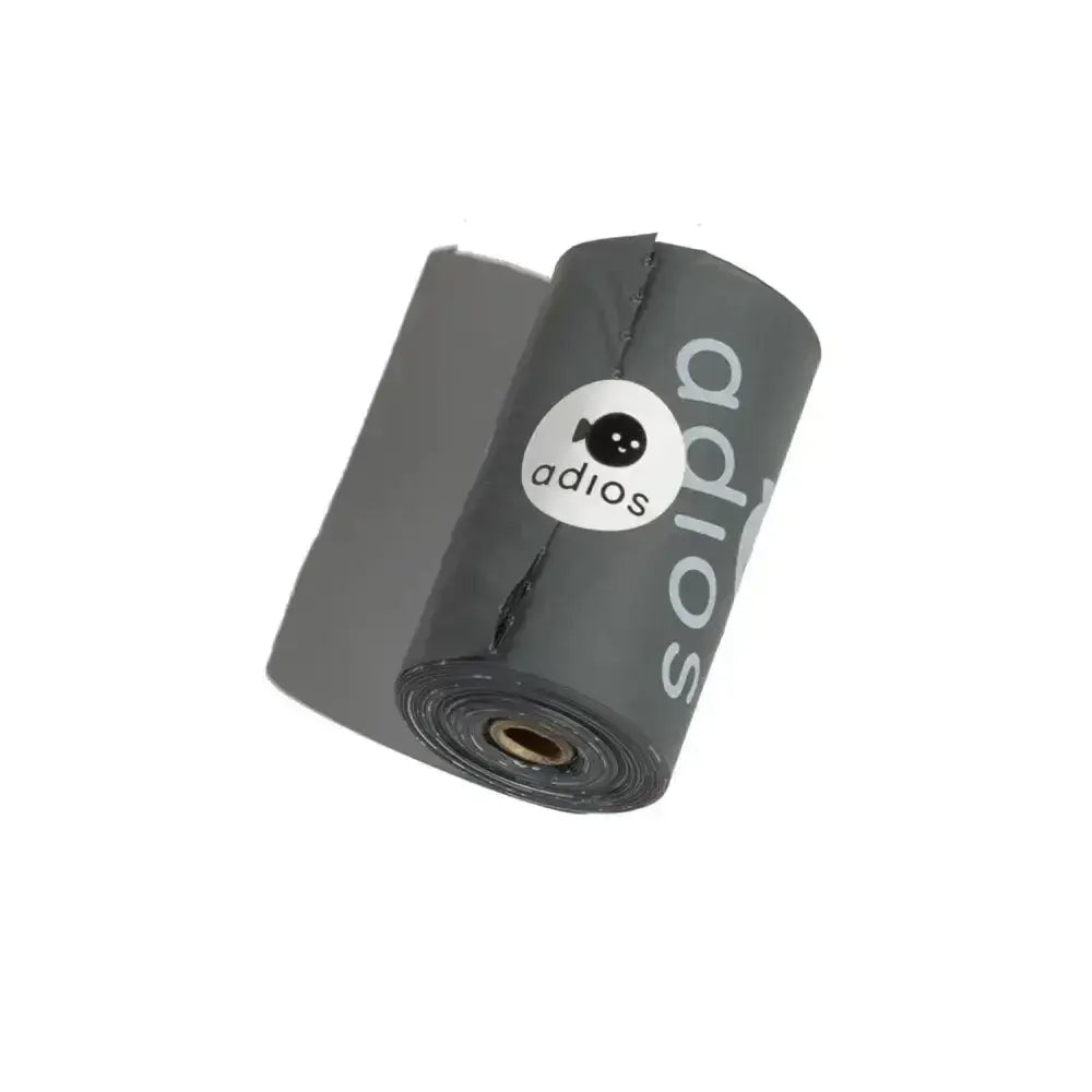 A roll of dark gray glossy plastic adios handle poo bags single with a white logo and black cartoon fish