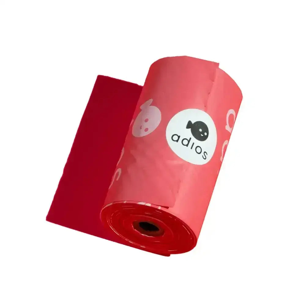 A roll of vibrant red glossy plastic adios non handle poo bags single roll with a white logo and cartoon fish design