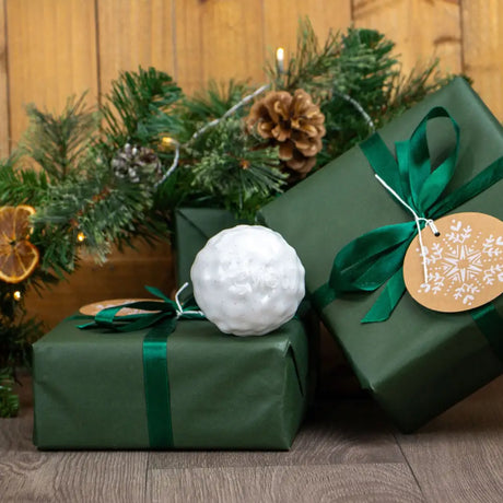 White textured spherical christmas ornament resting on green gift box from ancol bouncing snowball collection