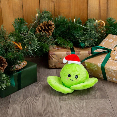 A soft lime green plush ancold bouncing spencer sprout toy with leaf arms wearing a red and white santa hat