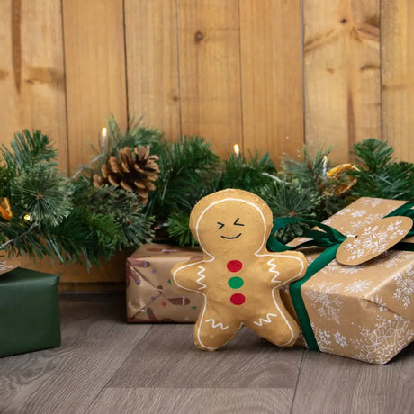 An ancol georgia gingerbread plush toy with tan fabric body and colorful red and green button details