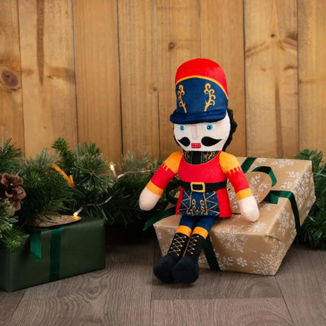 Ancol nicholas the nutcracker plush doll with red blue hat orange uniform sitting on wrapped gifts with equestrian flair