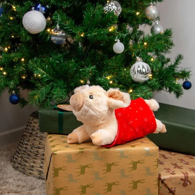 A fluffy beige plush ancol paloma pig wearing a red festive vest with gold snowflake patterns perfect for cozy gifts