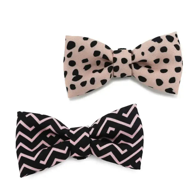 A pair of ancol soho pet bow ties with dalmatian polka dots and bold pink and black zig zag stripes