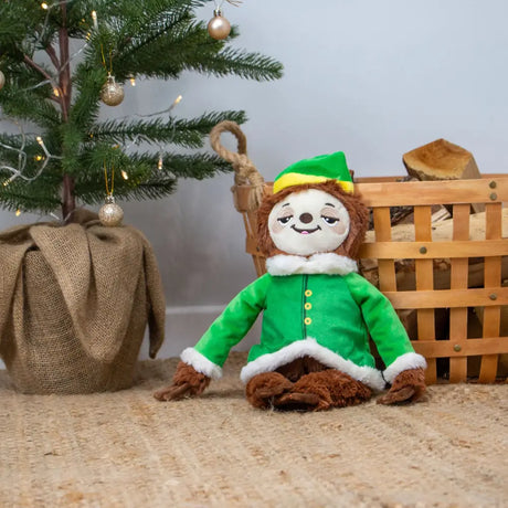A plush ancol stevie sloth dressed as an elf in a green velvet coat with white fur trim and yellow buttons