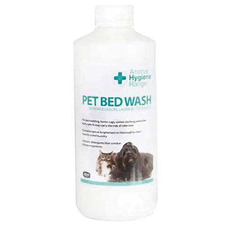 White plastic bottle of animal health company pet bed wash with teal black label showing cat dog for heavily soiled laundry