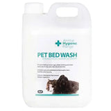White plastic jug with handle and cap labeled pet bed wash by animal health company for heavily soiled laundry