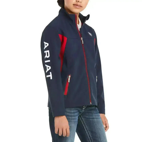 Navy blue ariat softshell jacket for kids with red zipper accents and white sleeve branding in colour block style