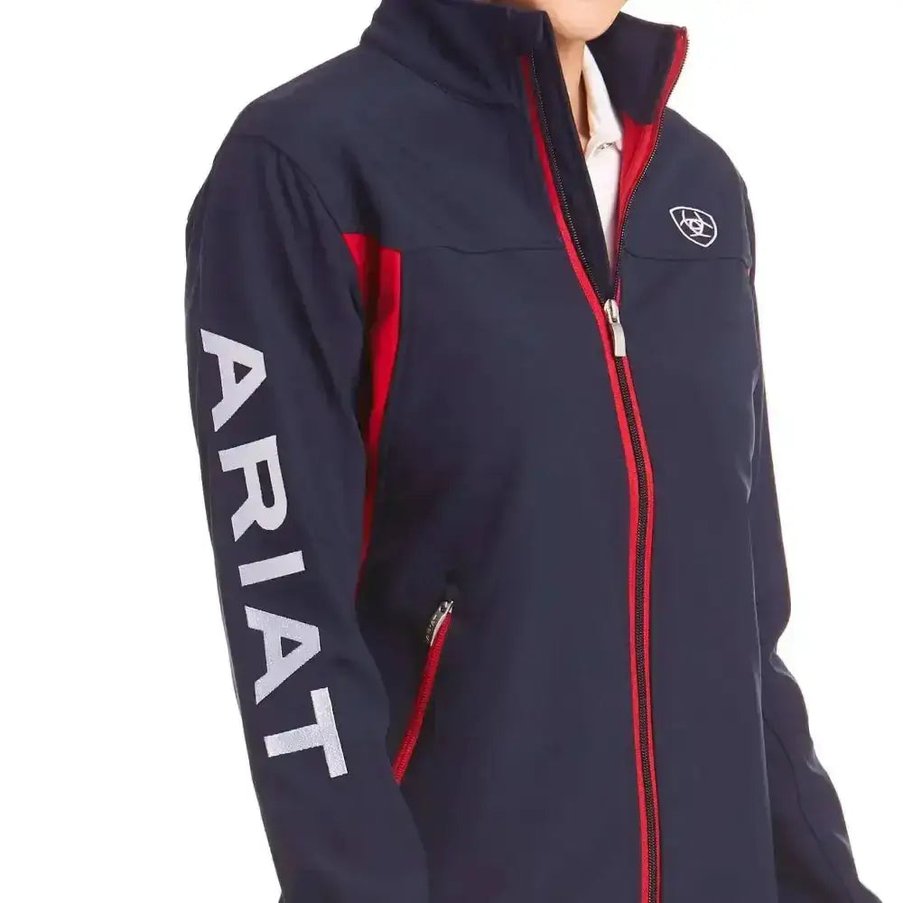 Navy blue ariat womans team softshell jacket with zip-up, red trim, white branding, and fierce colourblock styling