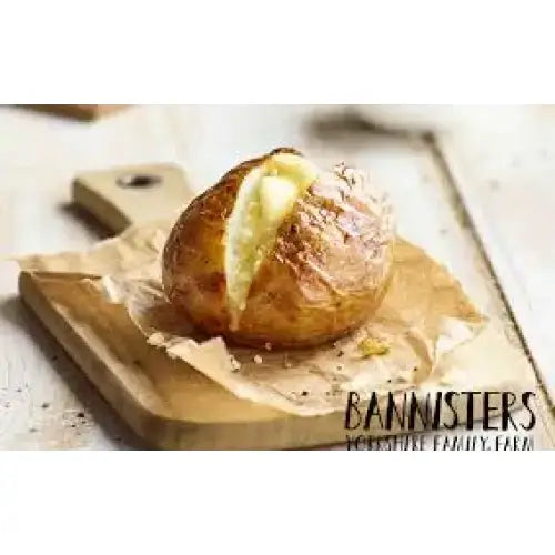 Golden-brown baked potato with split top and creamy butter inside resting on parchment paper perfect for equestrian meals
