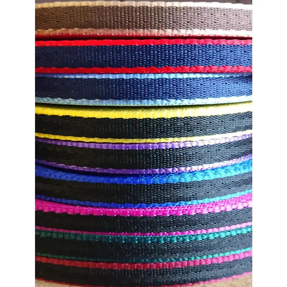 A stack of banbury headcollar straps in bright colors made of 16mm soft webbing with metal fittings for minis alpacas and llamas
