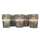Five benji & flo little paws groove mobility treats in matte brown pouches with colorful bands and clear windows showing treats