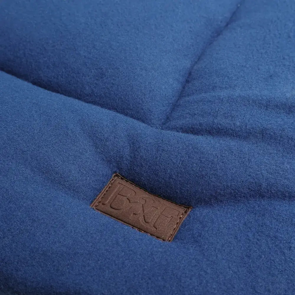 Blue quilted wool blanket with brown leather patch on benji and flo luxury fleece dog bed for cozy comfort