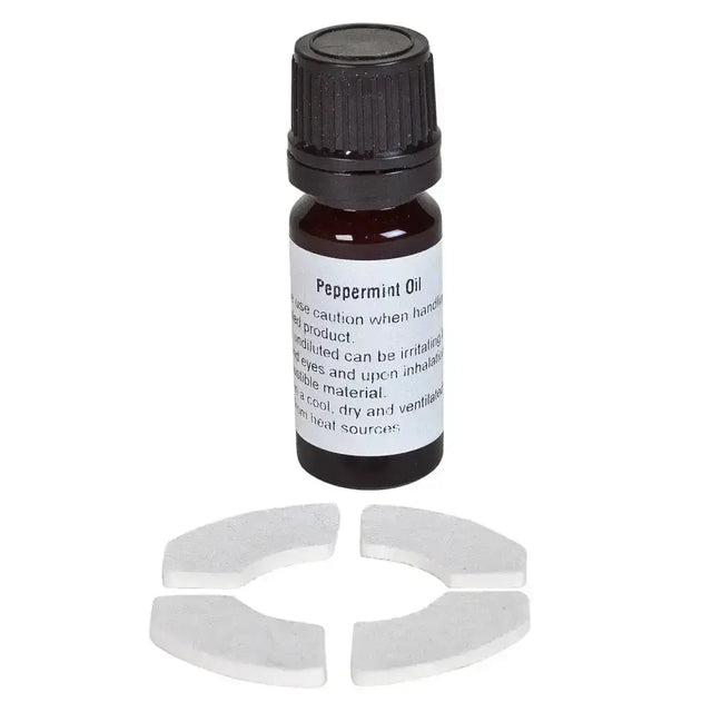 Dark amber glass bottle with black cap labeled peppermint oil next to white ceramic pieces in bizzy horse aromatherapy kit