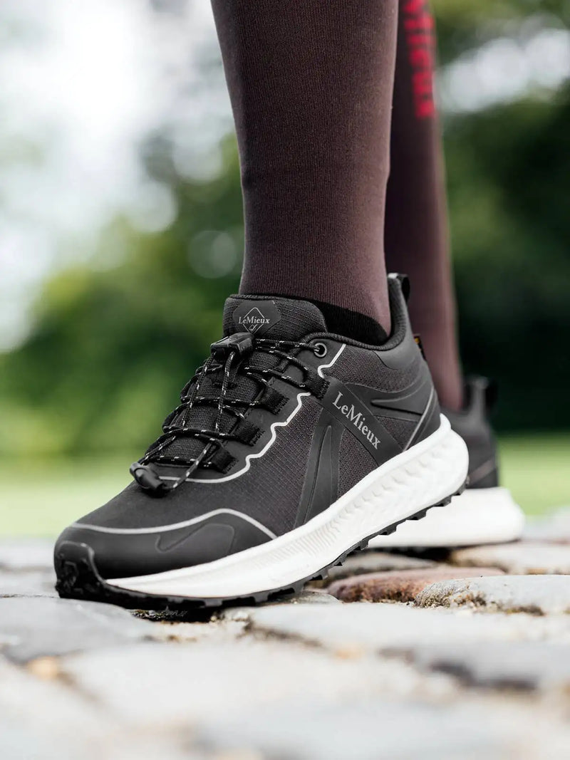 Black lemieux athletic shoe with white accents and a textured rubber sole.