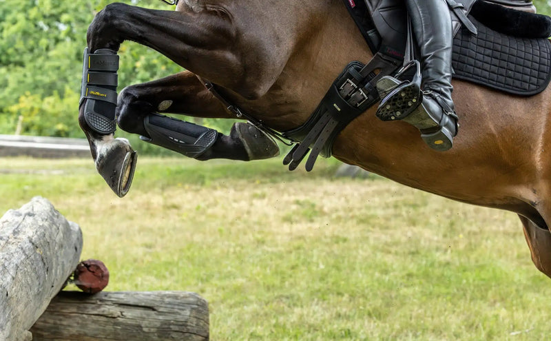 Black protective hoof boots with a textured, padded design and adjustable straps.