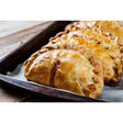 Golden-brown blackwell’s pasties devon flaky pastry pasties with rustic braided crust on a dark baking tray