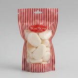 A red and white striped plastic bag filled with off-white oval candies from bon bon sweets pouches with sugar coatings